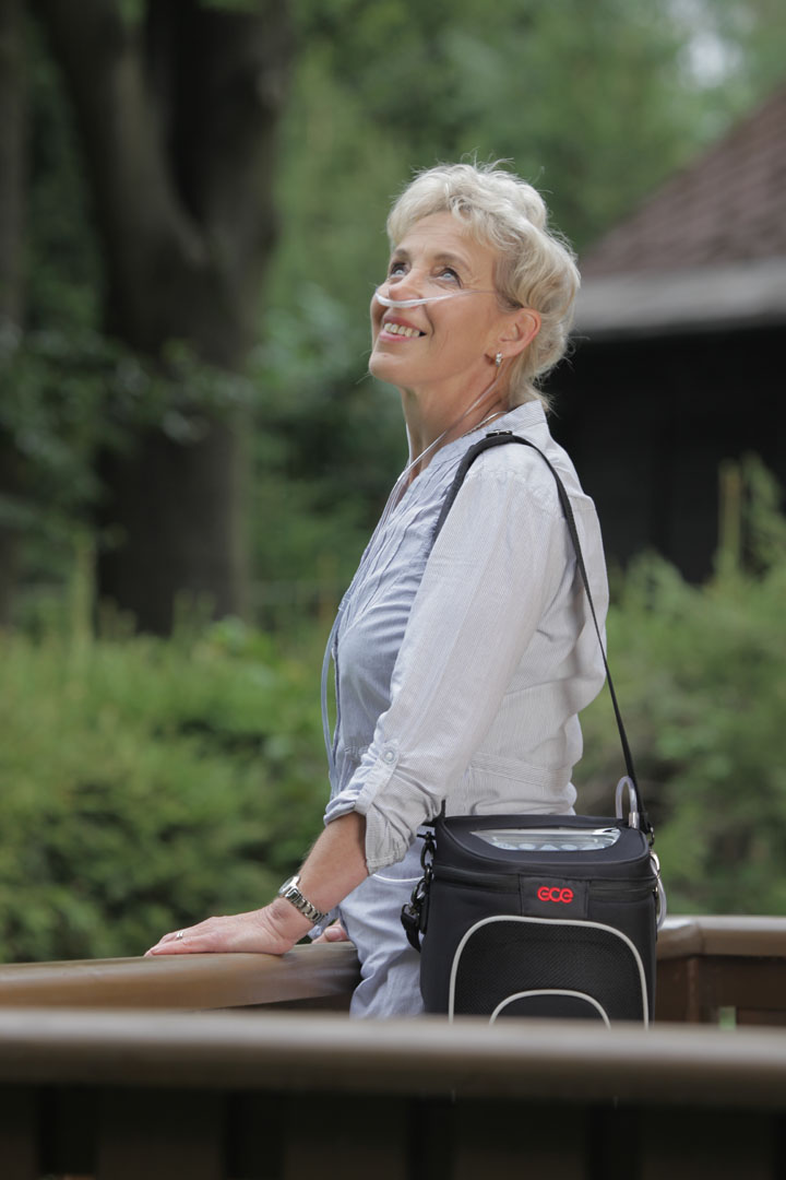 Zen-O Portable Oxygen Concentrator Woman Photo of a woman carrying the Zen-O Portable Oxygen Concentrator outside.